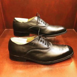 The Camilo Oxford comes in  black cow leather and a brogue toe lace up men's shoe It is hand-crafted which makes each pair unique. These men`s shoes features a natural leather lining And a blake-stitched leather outsole Distinguished by its elegant, elongated shape, this lace-up oxford is a testament to Zapato Sanchez's shoemaking craftsmanship. 