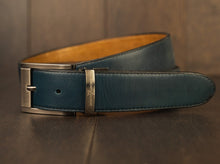 Load image into Gallery viewer, Hand made blue leather belts The ZapatoSanchez monogram is imprinted in its metalic buckle matching the blue leather in this belt introduced for Spring 2021. The blue stitching completes the accessory. Blue supreme blue leather with a tan coloured lining Metalic-toned hardware Belts are 1.5 inches wide and are measured from the end of the buckle to the center hole. Sizing may differ based on where the belt is worn (at the hips vs on the waist) 1.3/8 inches. Made in Canada
